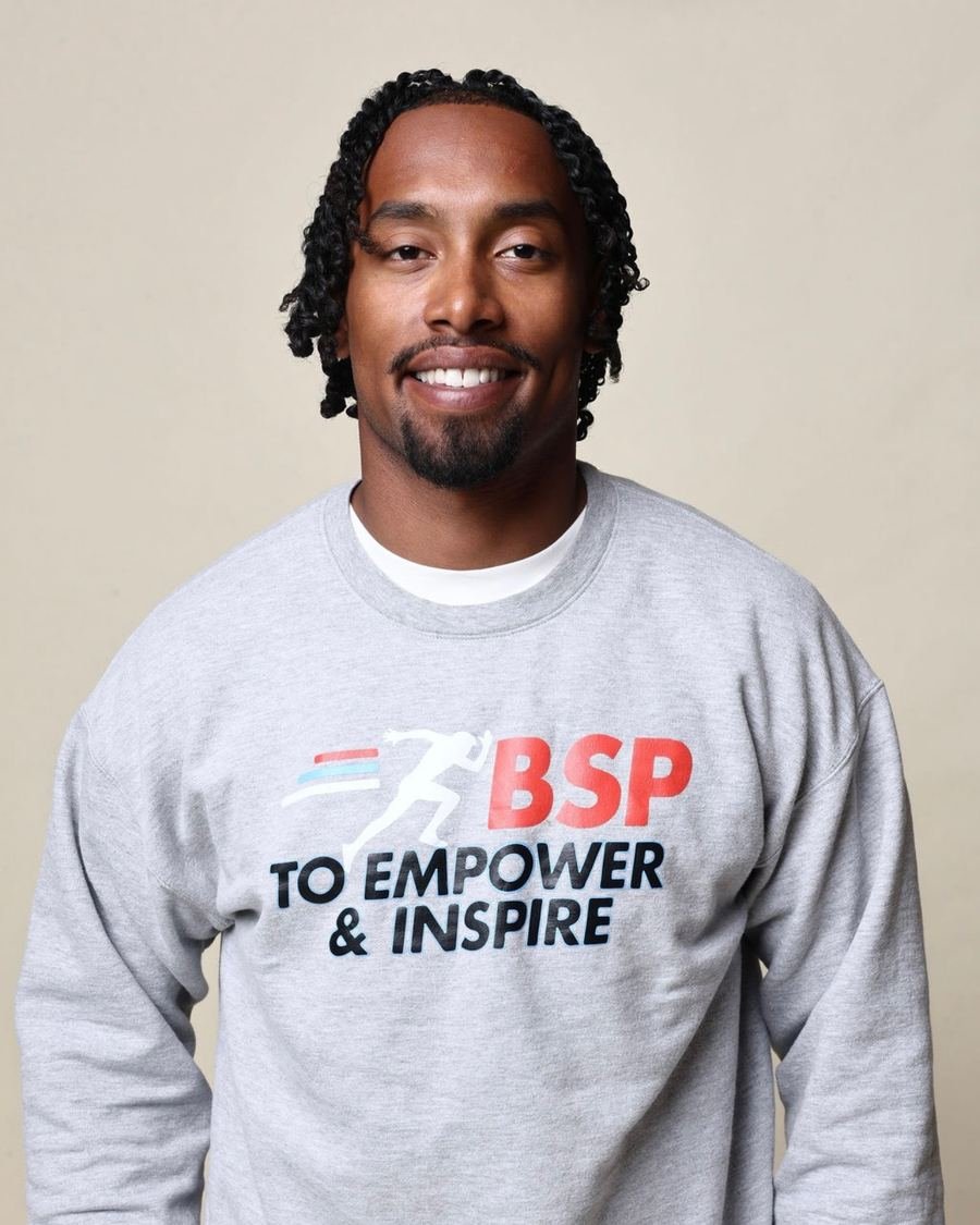 Avian Thomas smiling in a gray BSP To Empower and Inspire sweatshirt