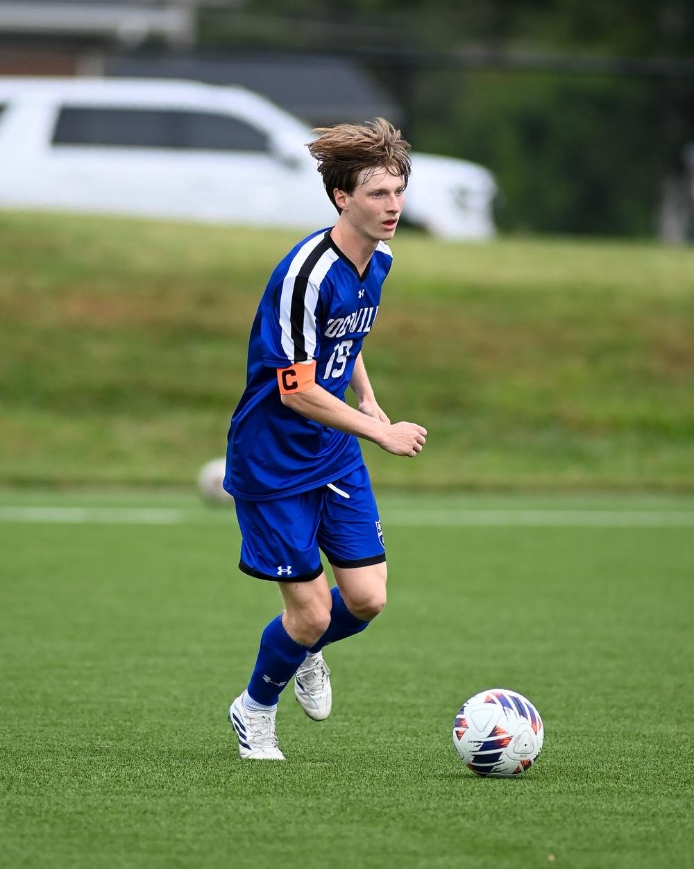 Soccer captain dribbling upfield